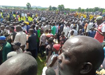Mourners struggle to catch a glimpse of the UPDF chopper that had arrived with carried the remains of Col Charles Okello Engola on May 11, 2023. COURTESY PHOTO.